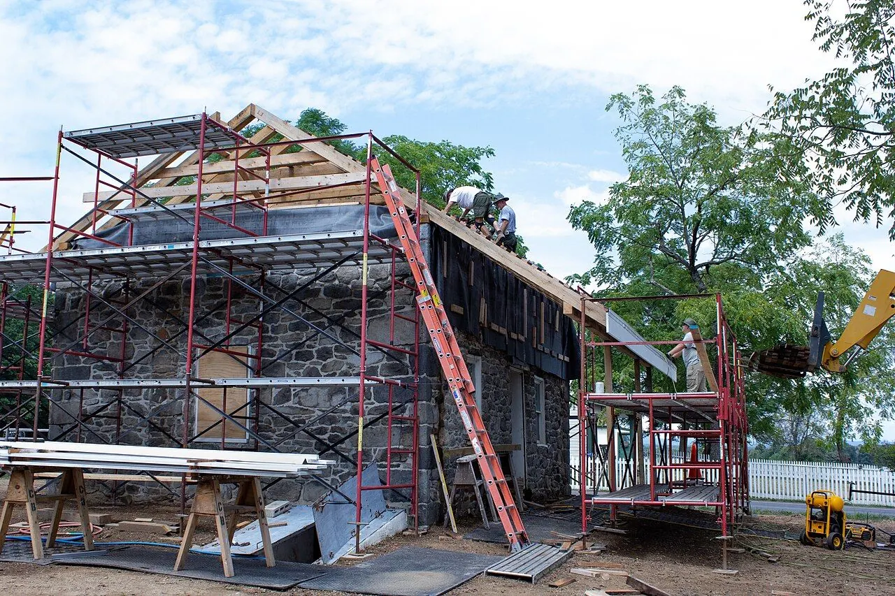Roofer installing wind-rated shingles on a sealed roof deck